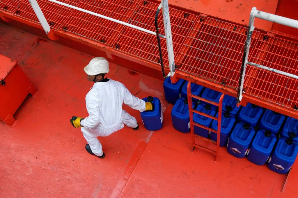 A man handling hazardous materials in an industrial zone