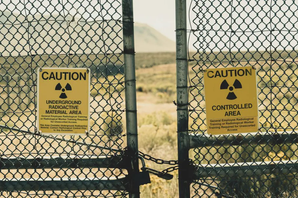 A radioactive Material Caution sign on a fence