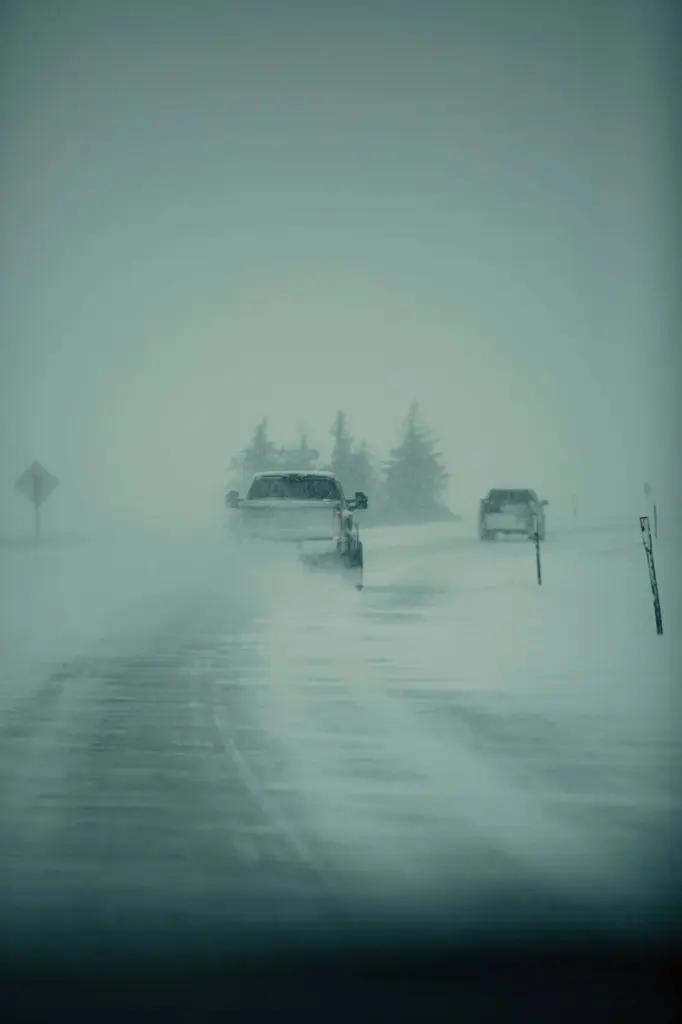 two trucks driving in a winter storm