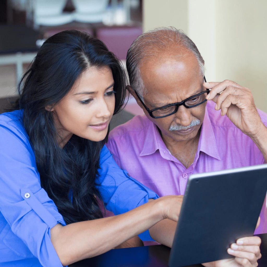 A woman helping an older adult with a tablet