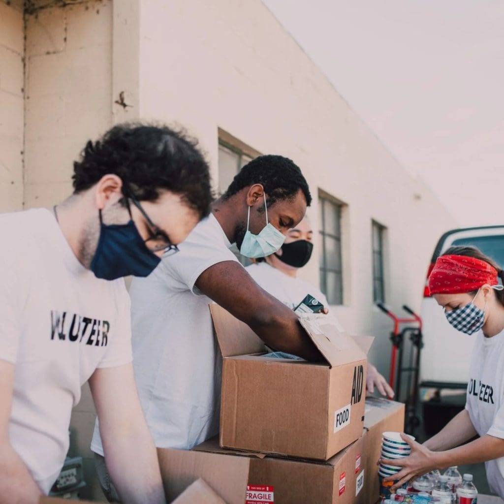 People handing out water and other goods to community