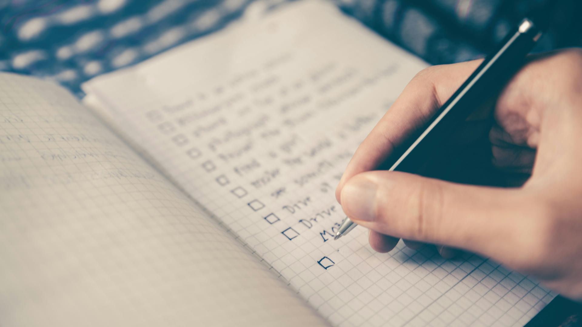 A person making a checklist on graph paper