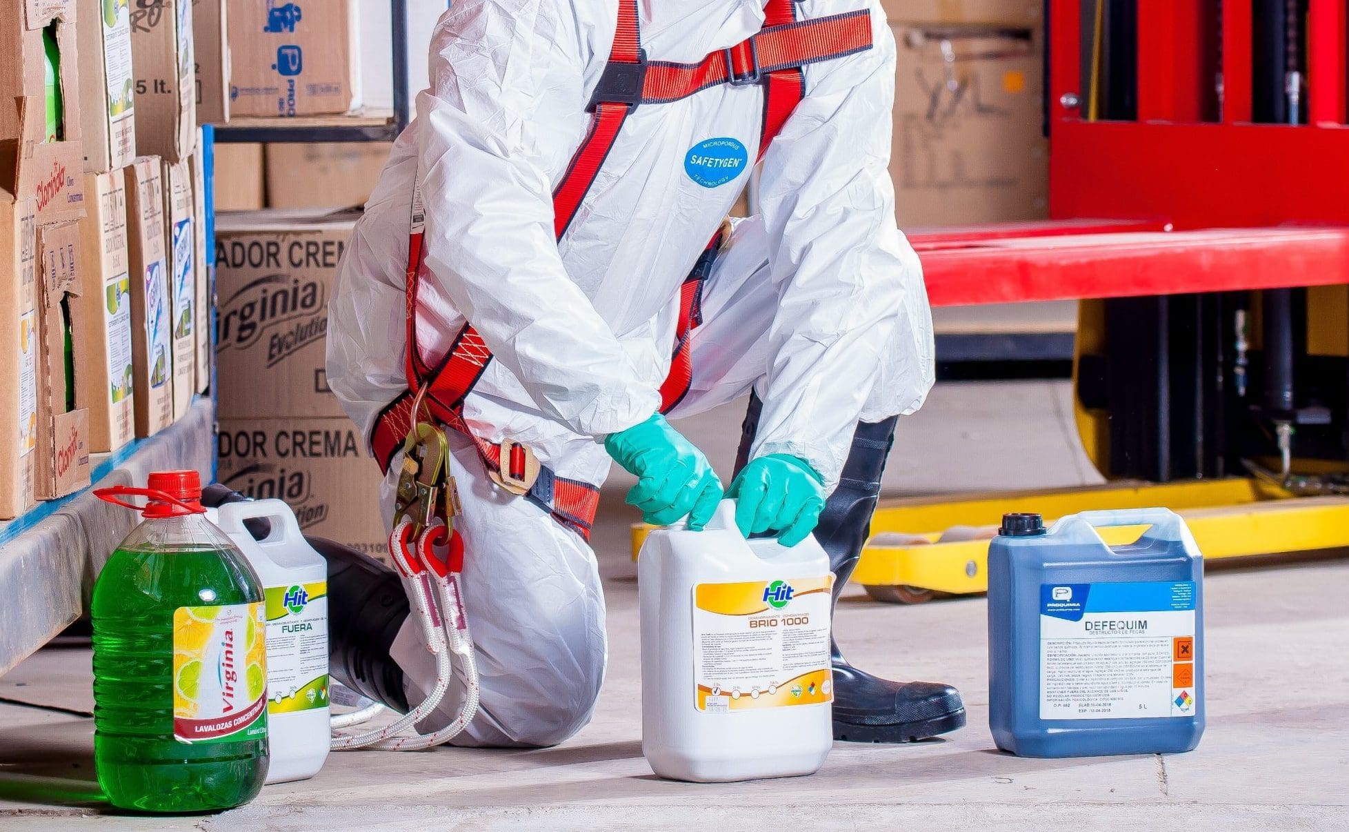 A person in a protective suit handling hazardous chemicals