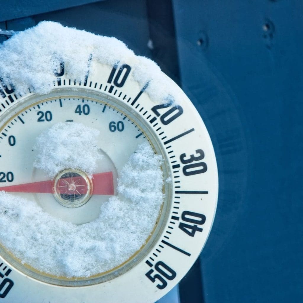 Frozen thermometer covered in snow