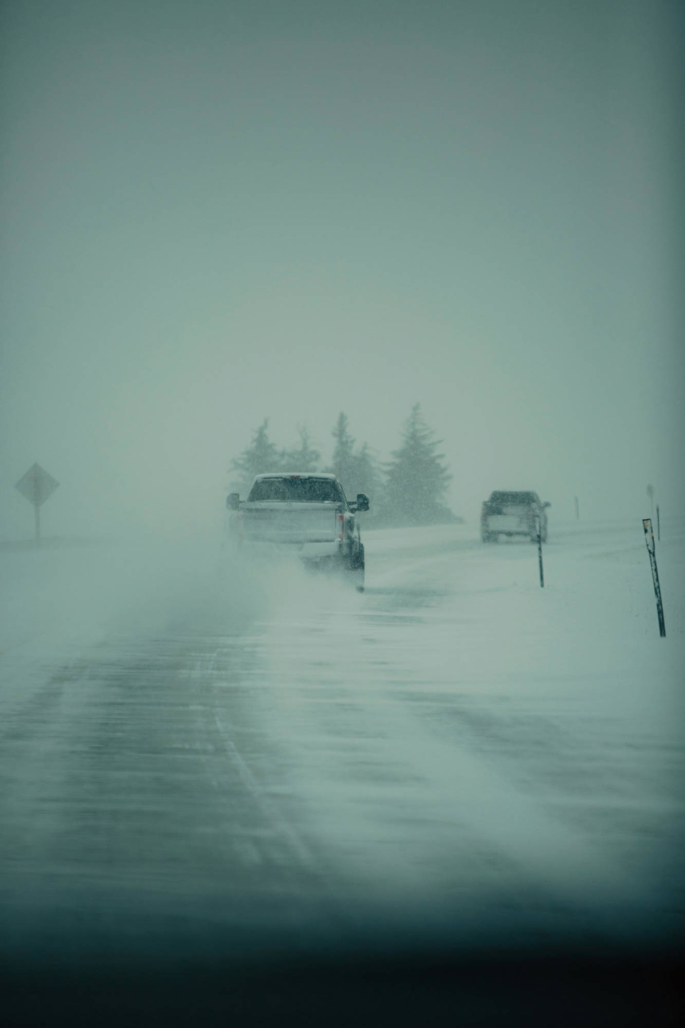 two trucks driving in a winter storm